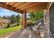 Charming covered patio with stone pillars, outdoor seating, and a view of the lush landscaped backyard at 6310 S Ider St, Aurora, CO 80016