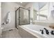 Bathroom featuring a soaking tub, a glass enclosed shower, and a window for natural light at 7814 Grady Cir, Castle Rock, CO 80108