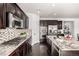 Well-equipped kitchen with granite counters, modern appliances, tile backsplash, and hardwood floors at 7814 Grady Cir, Castle Rock, CO 80108
