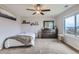 Cozy bedroom with neutral decor, ceiling fan, and a window overlooking the neighborhood at 14799 Longhorn Dr, Mead, CO 80542