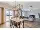 Bright open-concept dining area with a modern chandelier and access to the backyard at 14799 Longhorn Dr, Mead, CO 80542