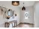 Stylish entryway with a wooden console table, decorative mirror, pendant lights, and a view of the front door at 14799 Longhorn Dr, Mead, CO 80542