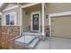 Inviting front porch with stone accents, a decorative wreath on the door, and a two-car garage to the side at 14799 Longhorn Dr, Mead, CO 80542