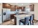 Modern kitchen featuring stainless steel appliances, a granite island with seating, and dark wood cabinetry at 14799 Longhorn Dr, Mead, CO 80542