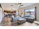 Open-concept living room featuring a large sectional sofa, hardwood floors, and seamless connection to the kitchen at 14799 Longhorn Dr, Mead, CO 80542