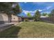 A large, grassy backyard featuring the back of the home, a small porch, and a wooden fence at 1099 Wheeling St, Aurora, CO 80011