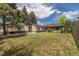 Expansive backyard view showcasing the house, a detached garage, and ample green space at 1099 Wheeling St, Aurora, CO 80011