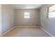 Carpeted bedroom with freshly painted gray walls and two bright, light-filled windows at 1099 Wheeling St, Aurora, CO 80011