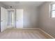 Neutral carpeted bedroom with ensuite and a doorway to a hall, freshly painted gray walls at 1099 Wheeling St, Aurora, CO 80011
