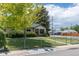 Charming home exterior with well-kept lawn, mature trees and fenced yard at 1099 Wheeling St, Aurora, CO 80011