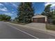 Two-car detached garage featuring brown doors, concrete driveway and partial view of home at 1099 Wheeling St, Aurora, CO 80011