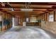 Large garage features exposed wood framing, concrete floor, and shelving at 1099 Wheeling St, Aurora, CO 80011