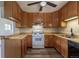 Kitchen featuring wood cabinets, tile backsplash, and white range at 1099 Wheeling St, Aurora, CO 80011