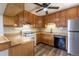 Kitchen featuring wood cabinets, tile backsplash, and white appliances at 1099 Wheeling St, Aurora, CO 80011