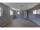 The living room is light-filled and neutral, with a door to the outside and wall-to-wall carpeting at 1099 Wheeling St, Aurora, CO 80011