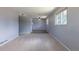 Carpeted living room with two bright windows and adjacent dining room with hard surface flooring at 1099 Wheeling St, Aurora, CO 80011
