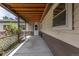 Covered patio with access to the home, complemented by vibrant rose bushes and a white-trimmed railing at 1099 Wheeling St, Aurora, CO 80011