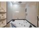 Corner bathtub with jacuzzi and shower, featuring beige tiles and a dark trim at 2372 Haskell Way, Watkins, CO 80137