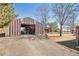 Exterior of a large metal garage with an open door and long driveway at 2372 Haskell Way, Watkins, CO 80137