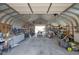 View of the metal garage interior filled with equipment, tools, and storage shelves at 2372 Haskell Way, Watkins, CO 80137