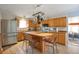 Eat-in kitchen featuring stainless steel appliances, wood cabinets, pot rack, and hardwood floors at 2372 Haskell Way, Watkins, CO 80137