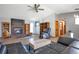 Comfortable living room featuring a brick fireplace, hardwood floors, and a large window at 2372 Haskell Way, Watkins, CO 80137