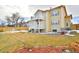 Spacious backyard view showcasing a two-story home with dual balconies, a grass yard and a garden at 288 Dover Ct, Broomfield, CO 80020