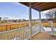 Relaxing balcony space with wood floors, white railing, and a view of the well-maintained backyard at 288 Dover Ct, Broomfield, CO 80020