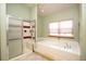 Bathroom featuring tiled floors, a glass shower, and a large soaking tub at 288 Dover Ct, Broomfield, CO 80020