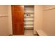 View of a spacious closet with multiple shelves, wooden door and metal hangers on wall at 288 Dover Ct, Broomfield, CO 80020