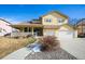 Charming yellow two-story home with attached two car garage and inviting covered front porch at 288 Dover Ct, Broomfield, CO 80020