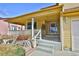 Covered front porch with white railings, columns and concrete steps to the front door at 288 Dover Ct, Broomfield, CO 80020