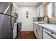 Modern kitchen featuring stainless steel appliances, white cabinetry, gray backsplash and wood floor at 3355 Hickok Pl, Boulder, CO 80301