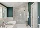 Well-lit bathroom featuring large glass shower, soaking tub, and stylish vanity with dark teal accent wall at 344 Saint Paul St, Denver, CO 80206