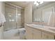 Clean bathroom featuring a glass enclosed tub, tile backsplash, and ample vanity storage at 344 Saint Paul St, Denver, CO 80206