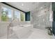 Bright bathroom featuring a freestanding tub, open windows, and walk-in shower with patterned tiles at 344 Saint Paul St, Denver, CO 80206