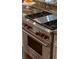 Stainless steel Wolf kitchen stove with red knobs set into granite countertops and custom white cabinets at 344 Saint Paul St, Denver, CO 80206