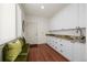 Spacious mudroom with storage cabinets, sink, wood floors, bench seating and an exterior door at 344 Saint Paul St, Denver, CO 80206