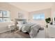 Staged bedroom showcases neutral tones, a comfortable bed, and great natural light from two windows at 875 E 78Th Ave # 9-2, Denver, CO 80229