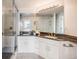 Bright bathroom featuring a double vanity with black granite countertop and a glass enclosed shower at 111 S Monroe St # B203, Denver, CO 80209