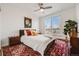 Cozy bedroom with a large window, ceiling fan and stylish decor at 111 S Monroe St # B203, Denver, CO 80209
