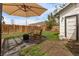 Inviting backyard seating area with rocking chairs, a fire pit, and a shade umbrella on a concrete patio at 3464 S Downing St, Englewood, CO 80113