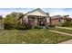 This single-story house has a welcoming front porch and an expansive green lawn at 3464 S Downing St, Englewood, CO 80113