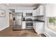 Well-lit kitchen with white cabinetry, stainless steel appliances, and hardwood floors at 3464 S Downing St, Englewood, CO 80113