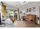 Bright living room featuring hardwood floors, neutral walls, access to a patio, a modern light fixture, and a piano at 3464 S Downing St, Englewood, CO 80113