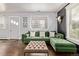 Inviting living room with hardwood floors, green sectional sofa, and a cozy ottoman at 3464 S Downing St, Englewood, CO 80113