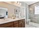Elegant primary bathroom featuring double vanity, large mirror, and glass-enclosed shower at 6240 N Dayton Ct, Denver, CO 80238