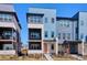 Modern townhome featuring a two-story facade, balcony, and a bright orange front door at 6240 N Dayton Ct, Denver, CO 80238