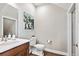 Neutral half bathroom with a wood vanity, white sink, and stylish decor at 6240 N Dayton Ct, Denver, CO 80238
