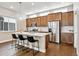 Open kitchen with wood cabinets, stainless steel appliances, island with quartz countertop and seating at 6240 N Dayton Ct, Denver, CO 80238